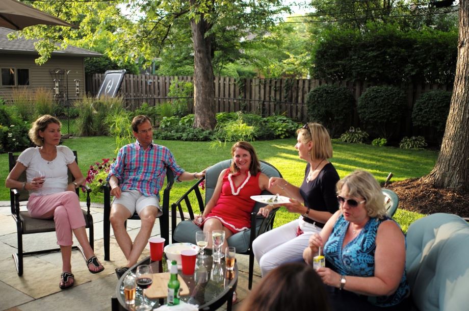 group of friends in a garden socialising at a bbq