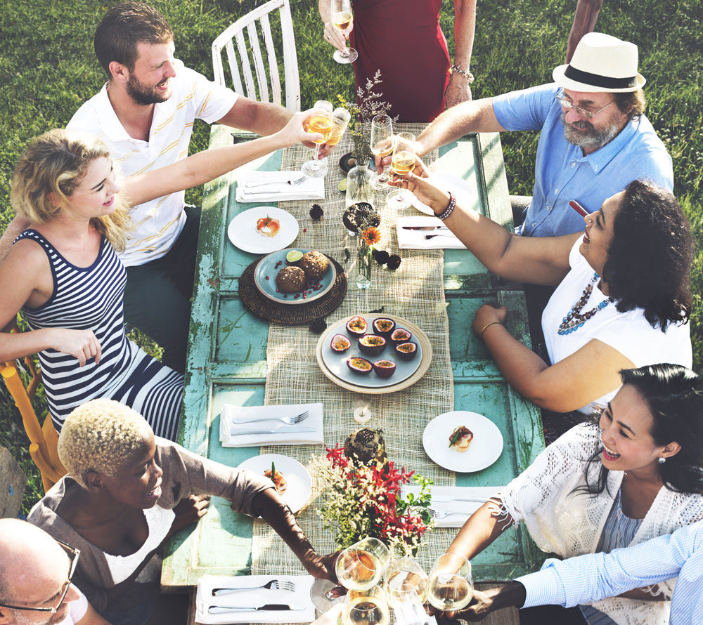 outside family dinner party with alcohol and food off a Cinders commercial bbq grill