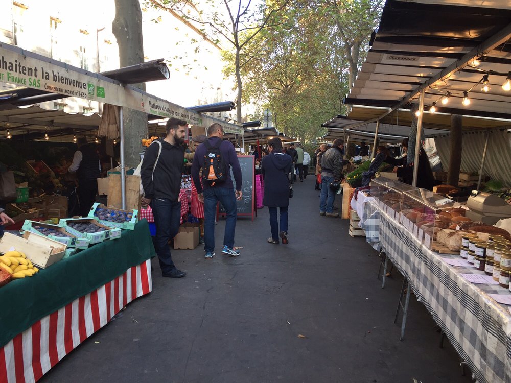 Market stalls with people, fruit, honey and produce
