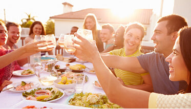 Friends celebrating and saying cheers at outside dinner party