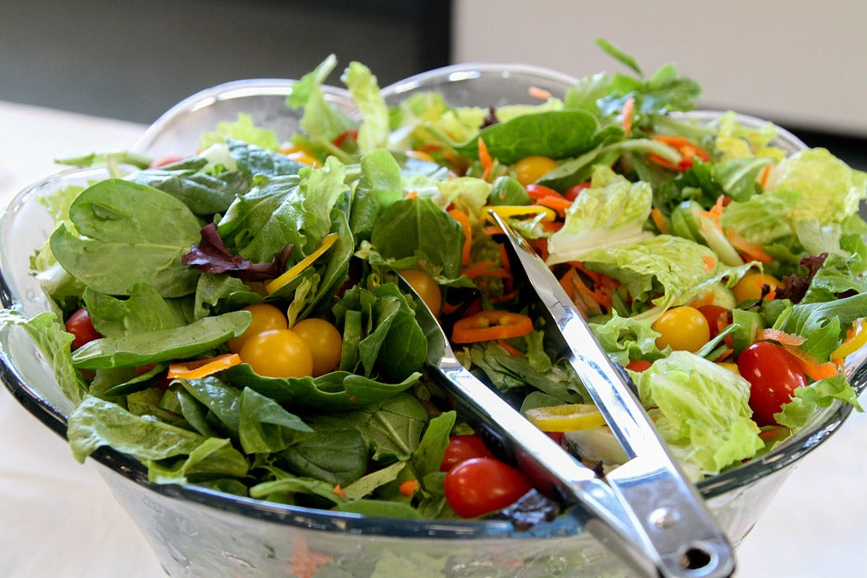 salad in a bowl with tongs
