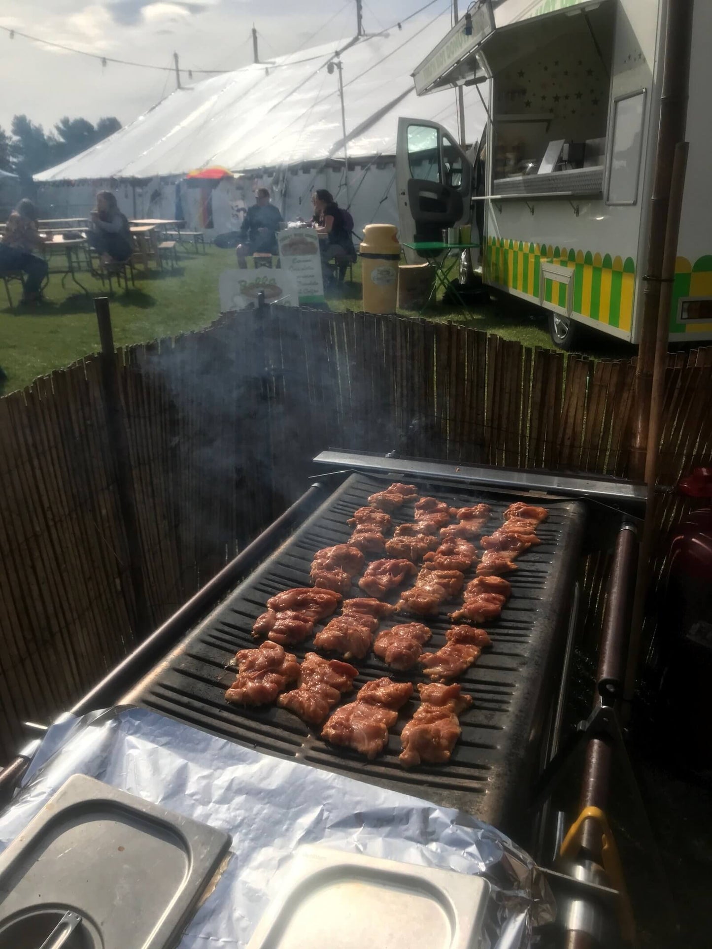 Cinders barbecue setup at outdoor festival with trailer