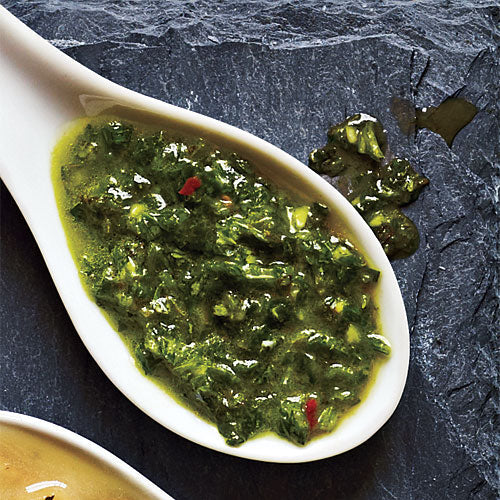 Green sauce on a spoon and slate place setting - this sauce is great for brushing on meats cooking on a commercial barbecues.